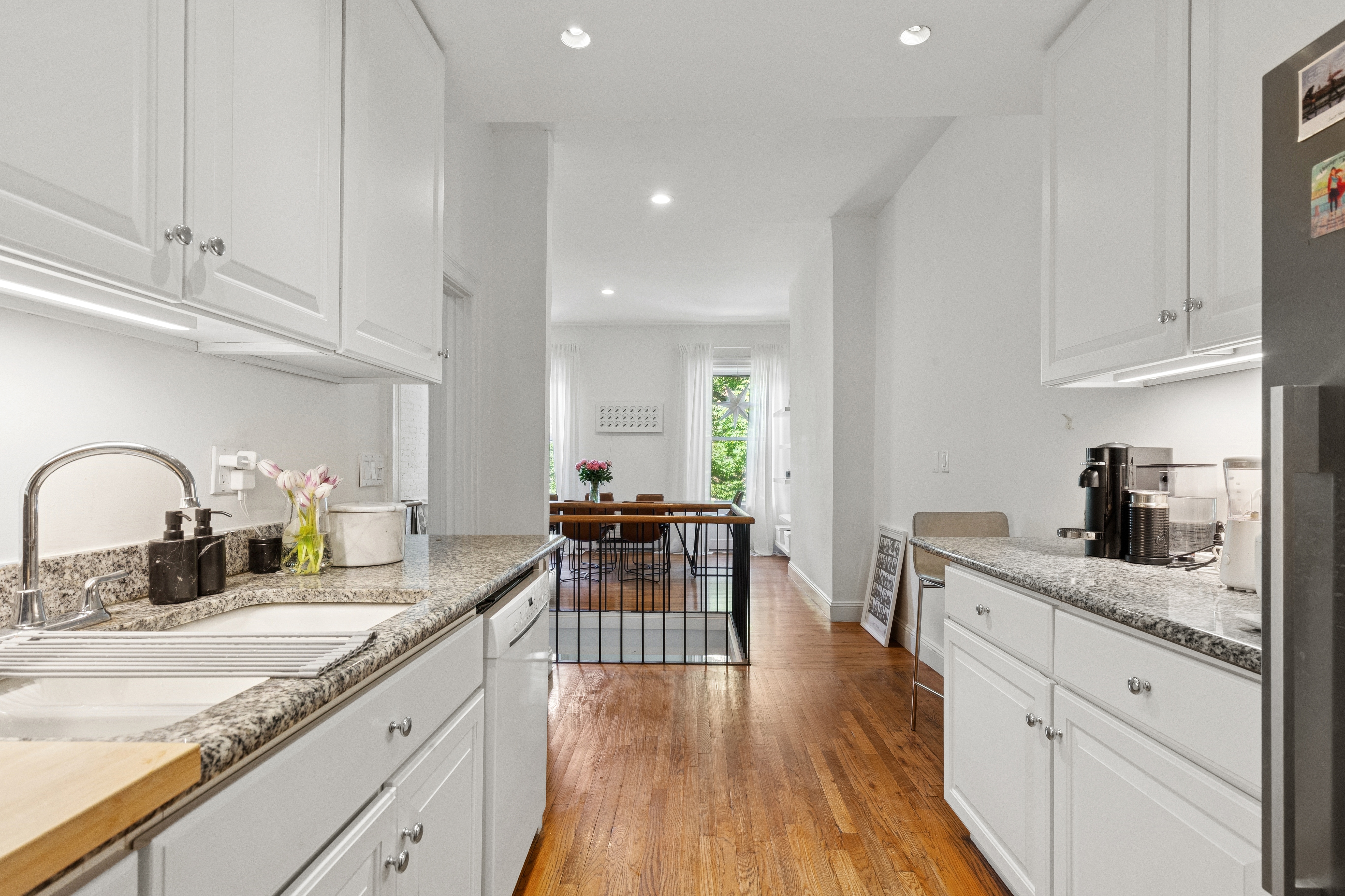 53 West 82nd Street, Unit 2 Manhattan, NY 10024 - Photo 3 of 10 a kitchen with granite countertop white cabinets and white appliances