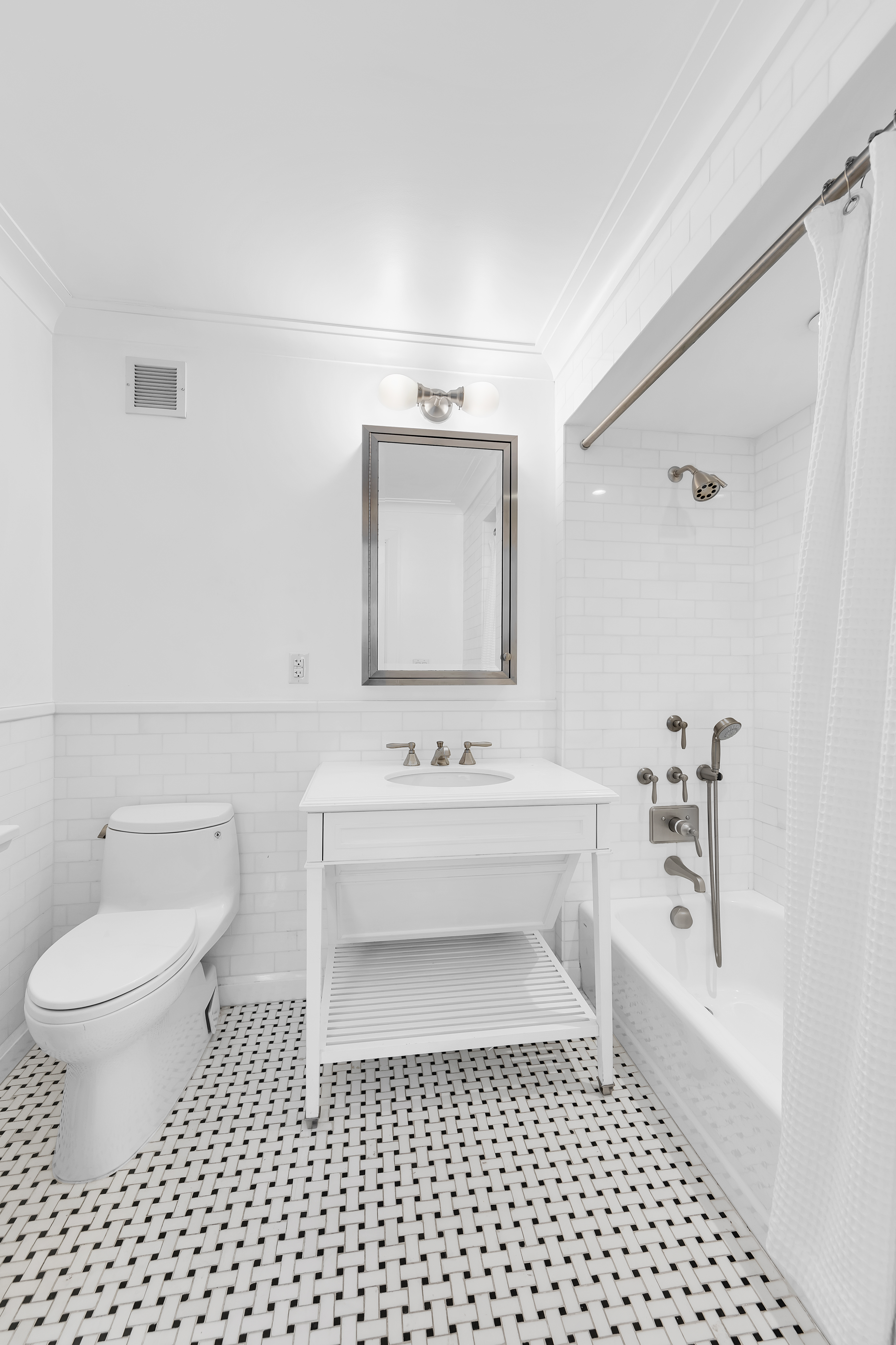 530 Park Avenue, Unit 17A Manhattan, NY 10065 - Photo 14 of 22 a bathroom with a bathtub a sink a toilet and a mirror