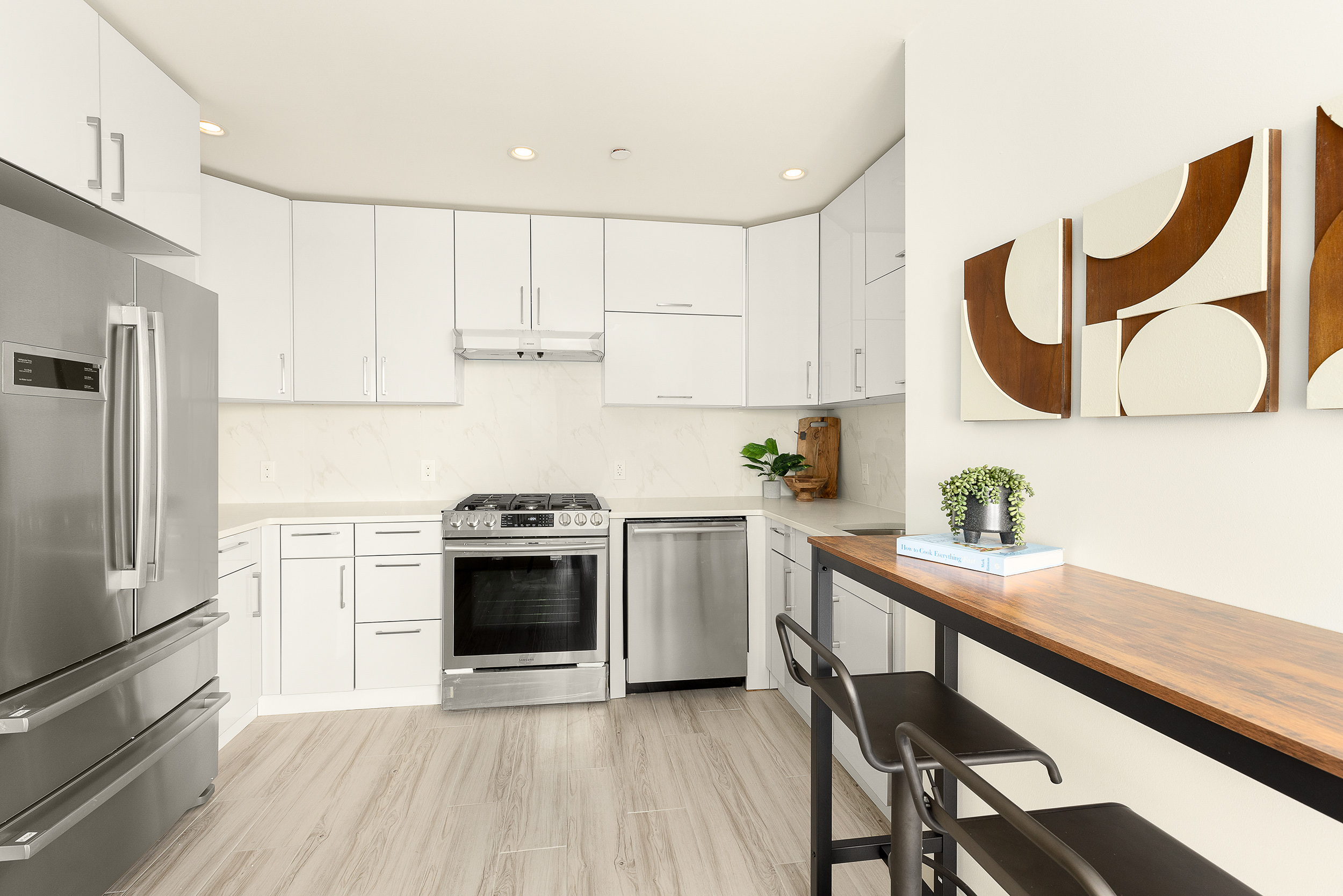 109-09 15th Avenue, Unit PHS611 Queens, NY 11356 - Photo 2 of 11 a kitchen with stainless steel appliances granite countertop a stove a sink dishwasher and a refrigerator with wooden floors