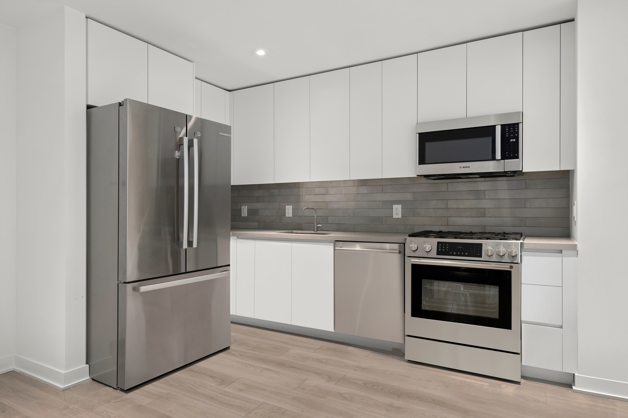 160 Front Street, Unit 517 Brooklyn, NY 11201 - Photo 2 of 14 a kitchen with granite countertop a refrigerator stove and microwave