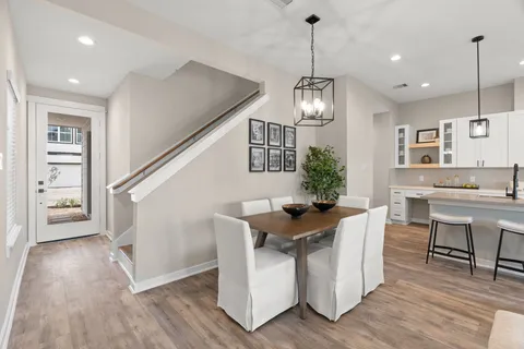 a view of a dining room with furniture a chandelier and wooden floor