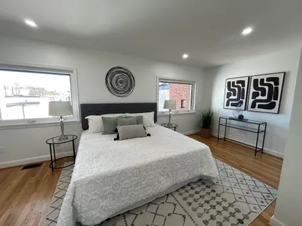 a bedroom with a bed and a table with wooden floor