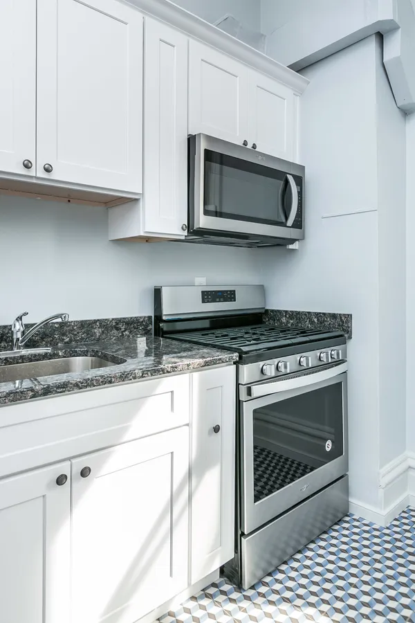 a kitchen with stainless steel appliances granite countertop a stove a microwave and oven