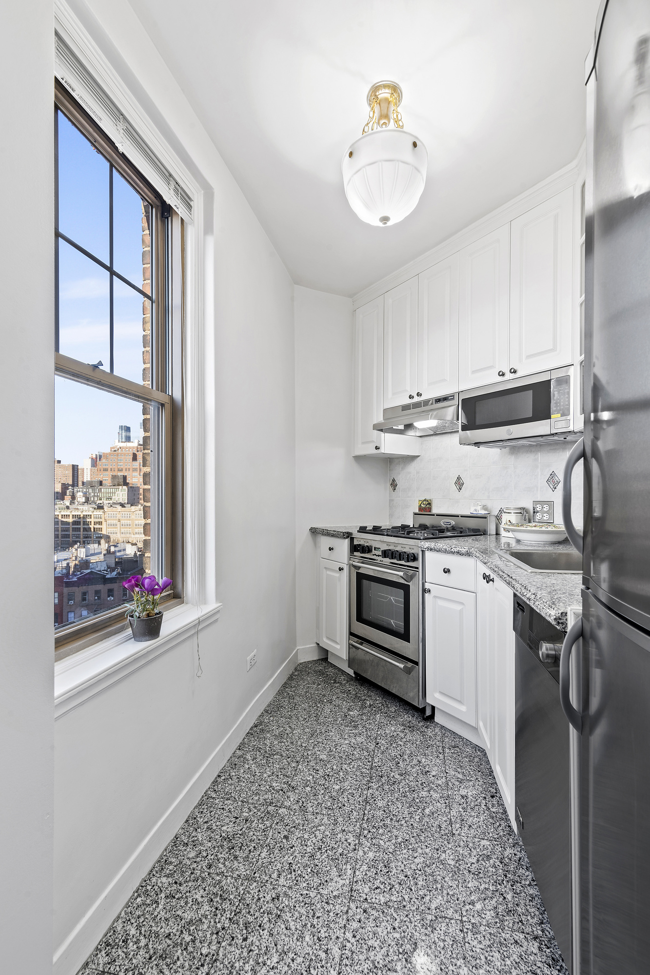 302 West 12th Street, Unit 12C Manhattan, NY 10014 - Photo 4 of 13 a kitchen with a stove a sink and a refrigerator