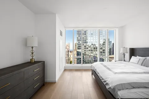 a bedroom with a bed and a large window