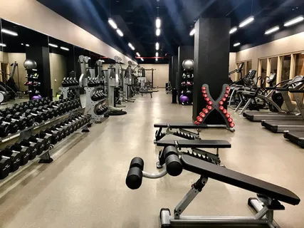 a room with gym equipment and lots of wooden walls