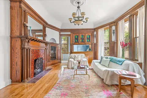 a living room with furniture a fireplace and a large window