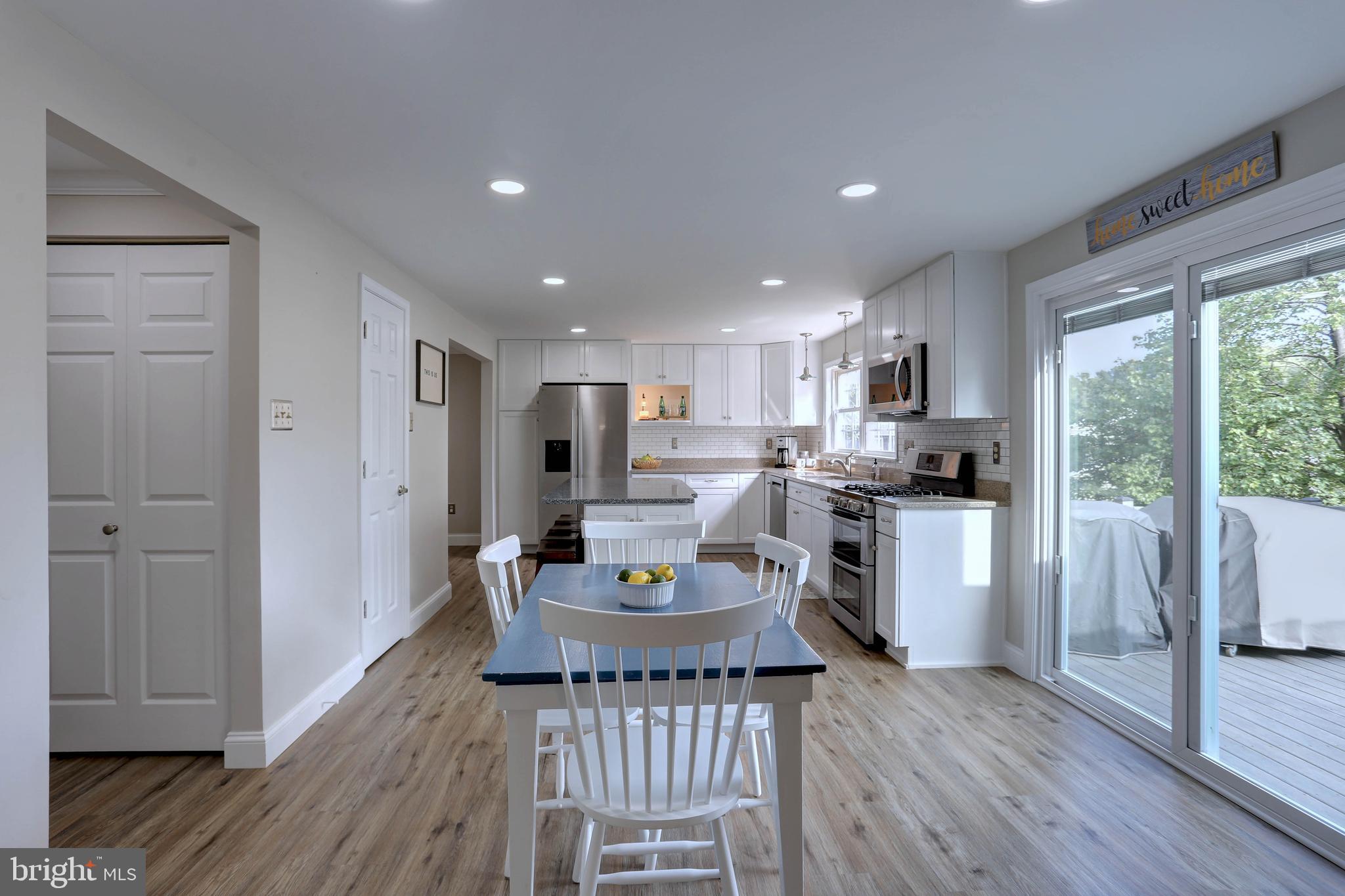 6257 Fairbourne Court Hanover, MD 21076 - Photo 12 of 47 a kitchen with a table chairs refrigerator and microwave
