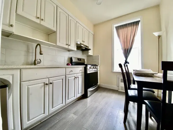 a kitchen with a table chairs sink and cabinets