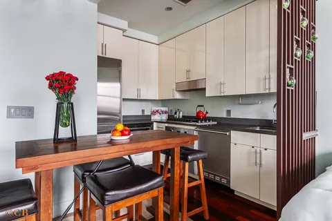 a kitchen with stainless steel appliances granite countertop a refrigerator sink and white cabinets
