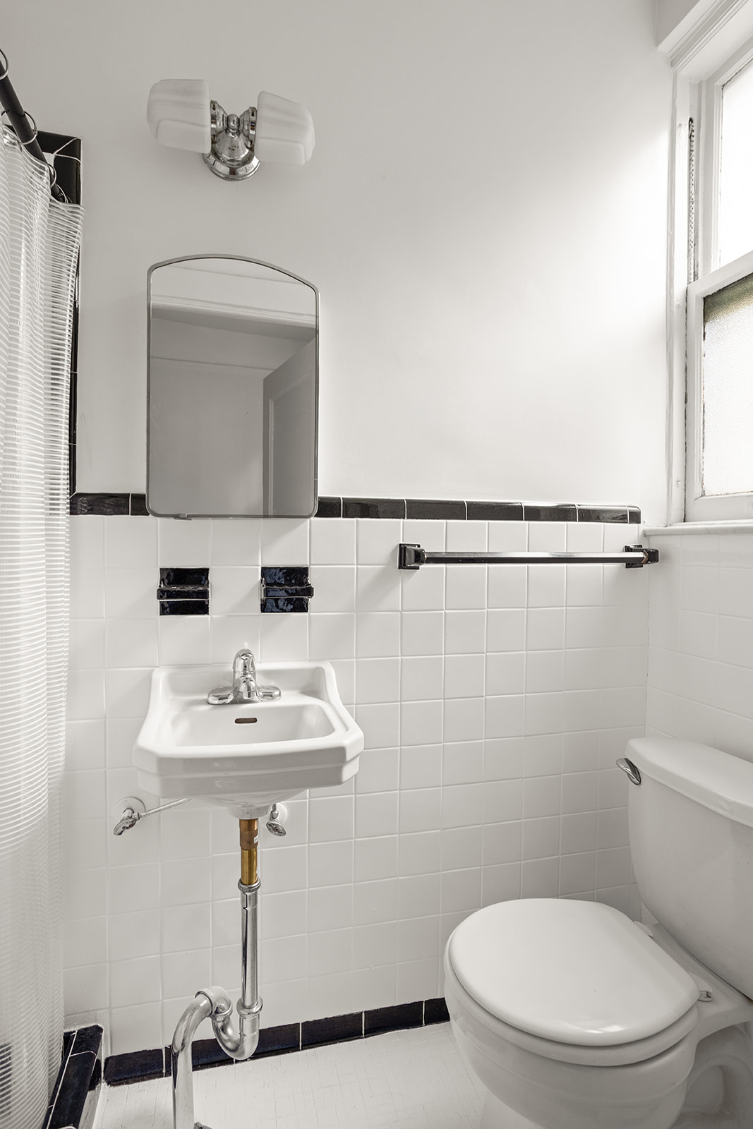 35-47 80th Street, Unit 2 Queens, NY 11372 - Photo 9 of 12 a bathroom with a sink a mirror and a toilet