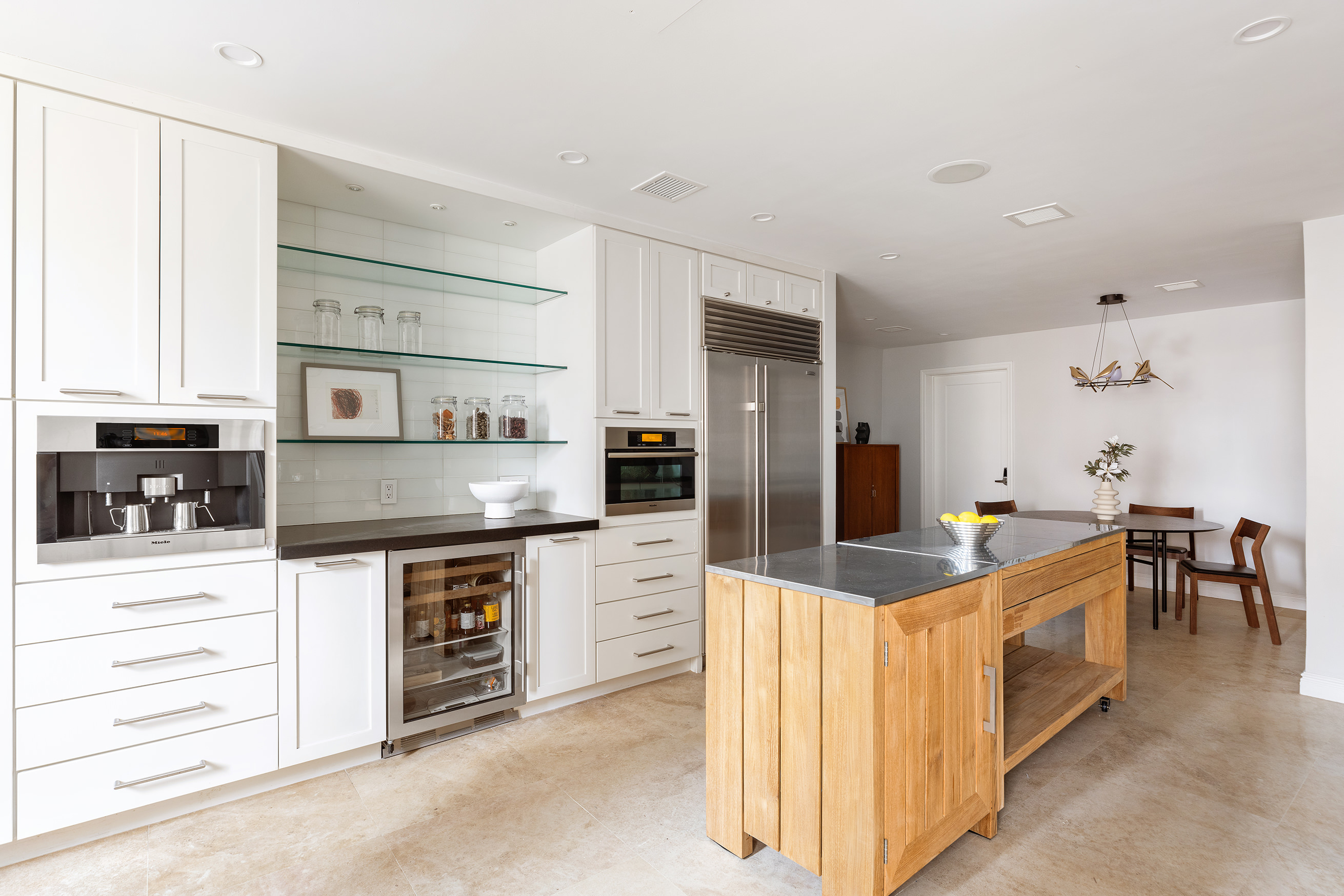 180 East 79th Street, Unit 14G Manhattan, NY 10075 - Photo 4 of 12 a large kitchen with stainless steel appliances kitchen island granite countertop a large counter top and white cabinets