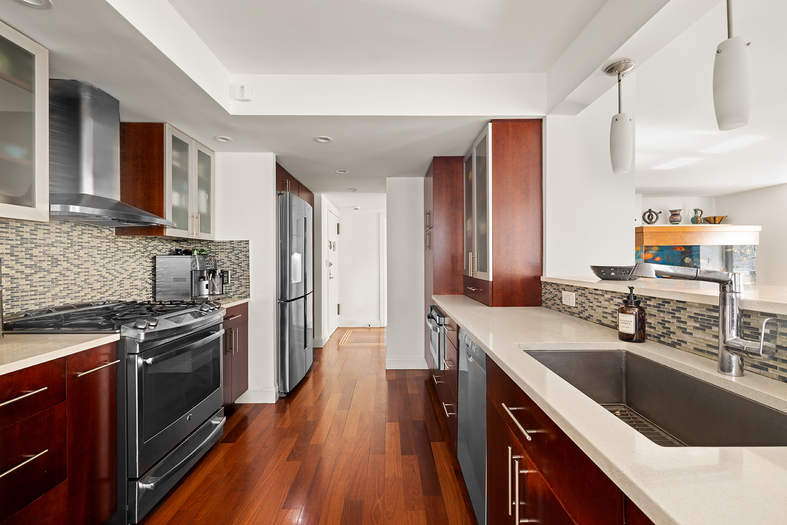 330 East 49th Street, Unit 12E Manhattan, NY 10017 - Photo 5 of 16 a kitchen with a sink stove top oven and cabinets