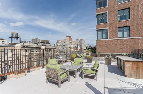 a roof deck with couch and chairs