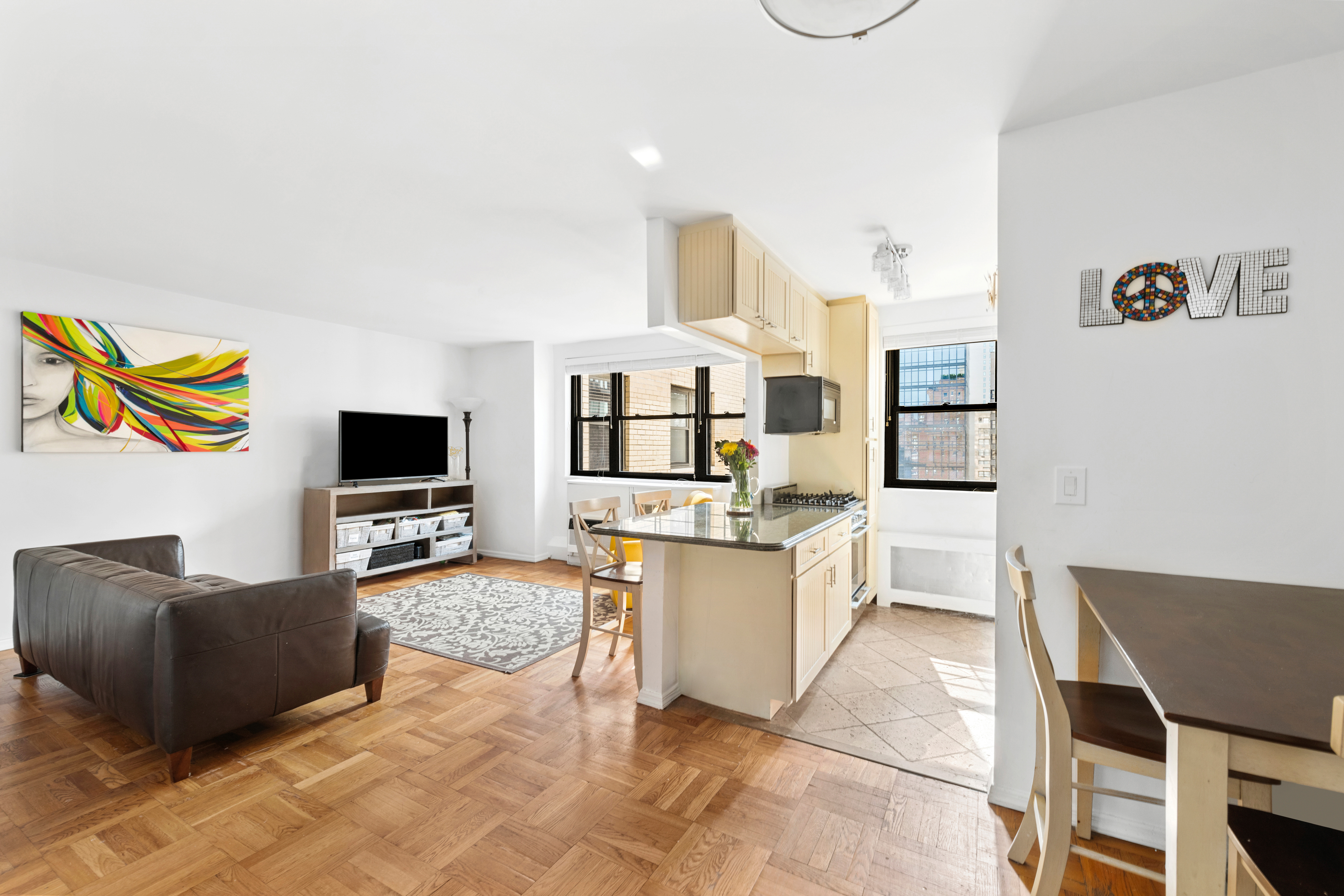 315 East 72nd Street, Unit 15M Manhattan, NY 10021 - Photo 3 of 18 a living room with furniture and a flat screen tv