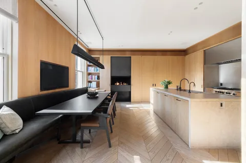 a living room with furniture a flat screen tv and kitchen view
