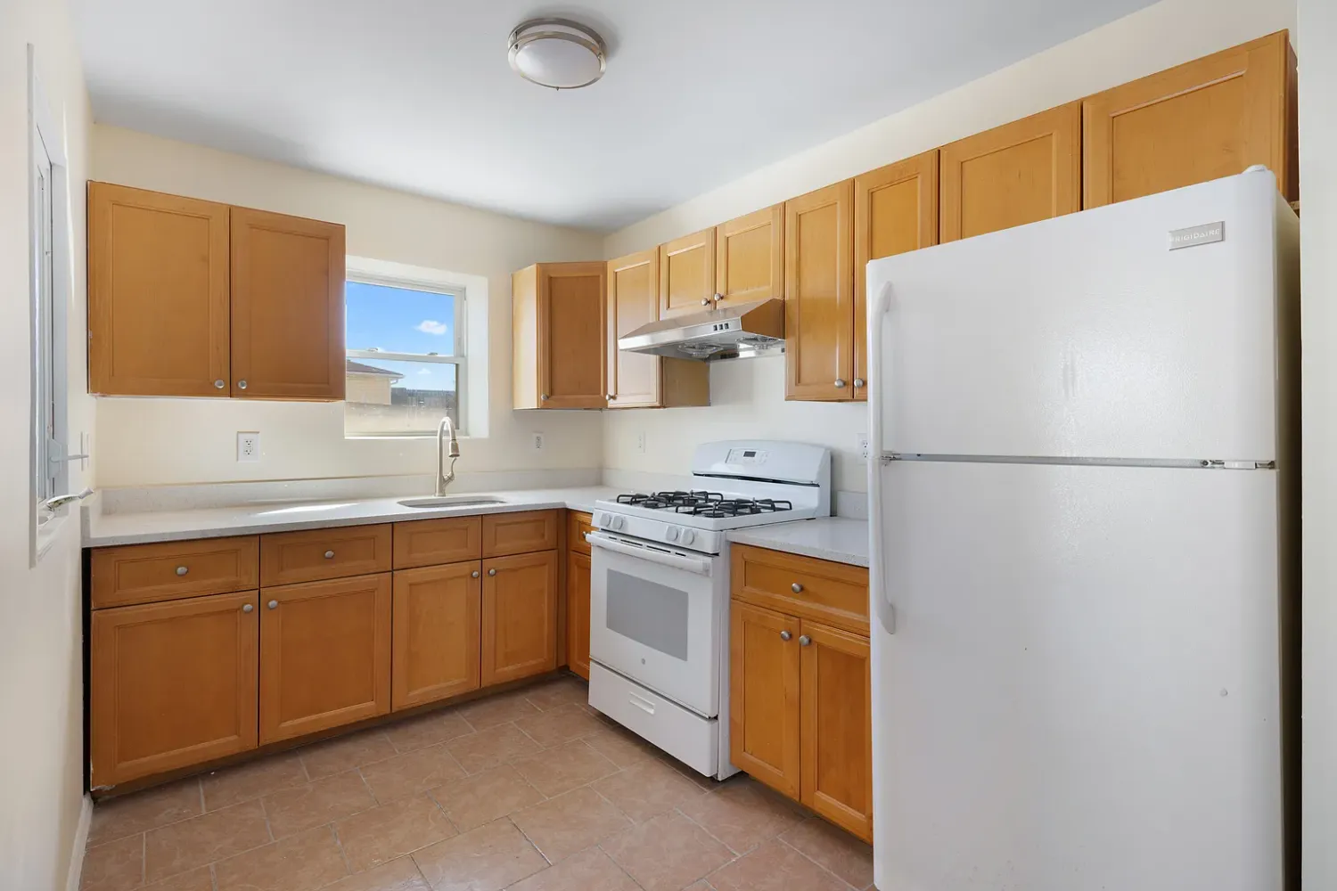 a kitchen with stainless steel appliances granite countertop a refrigerator a stove and a sink