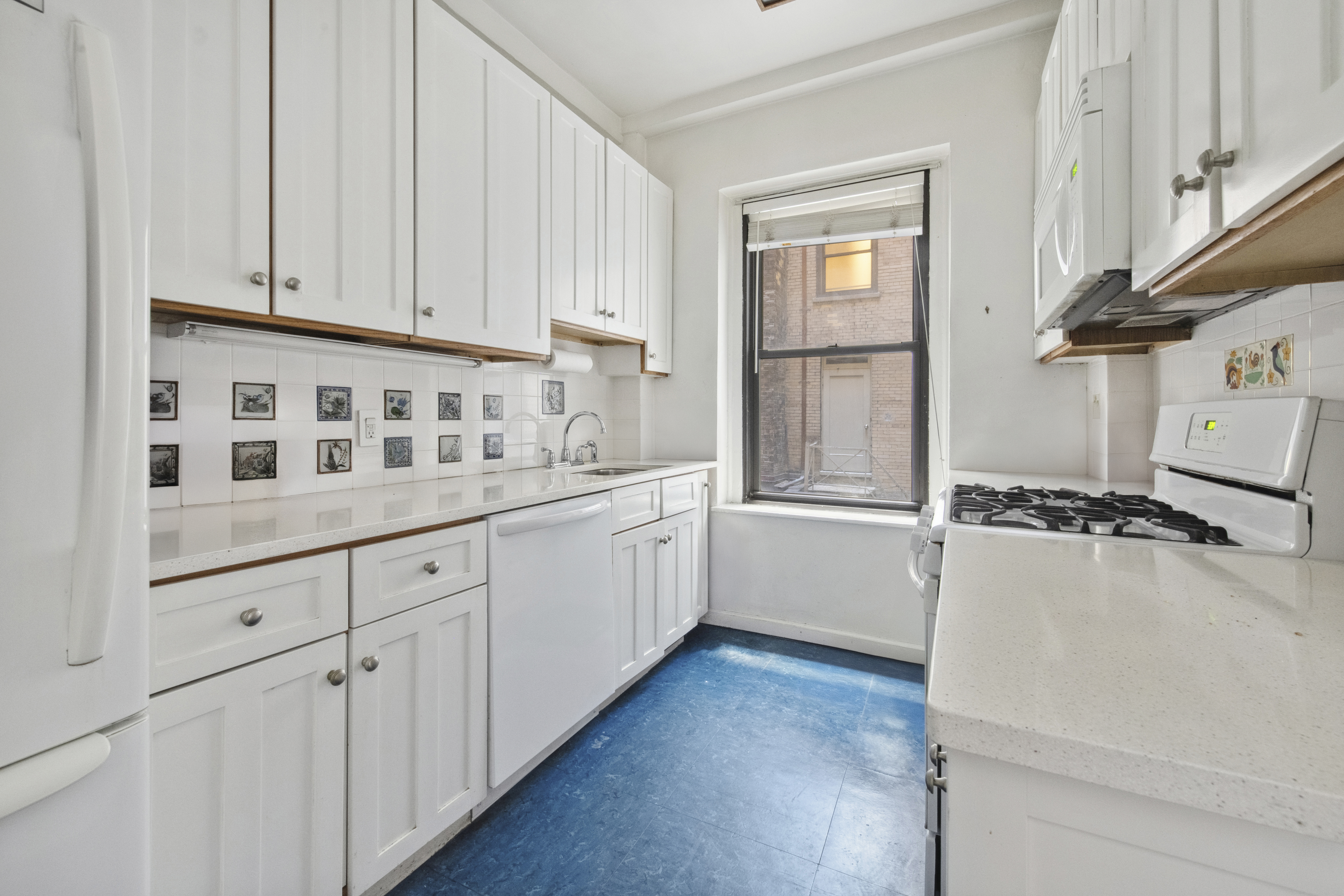 609 West 114th Street, Unit 2 Manhattan, NY 10025 - Photo 12 of 16 a kitchen with cabinets and white appliances