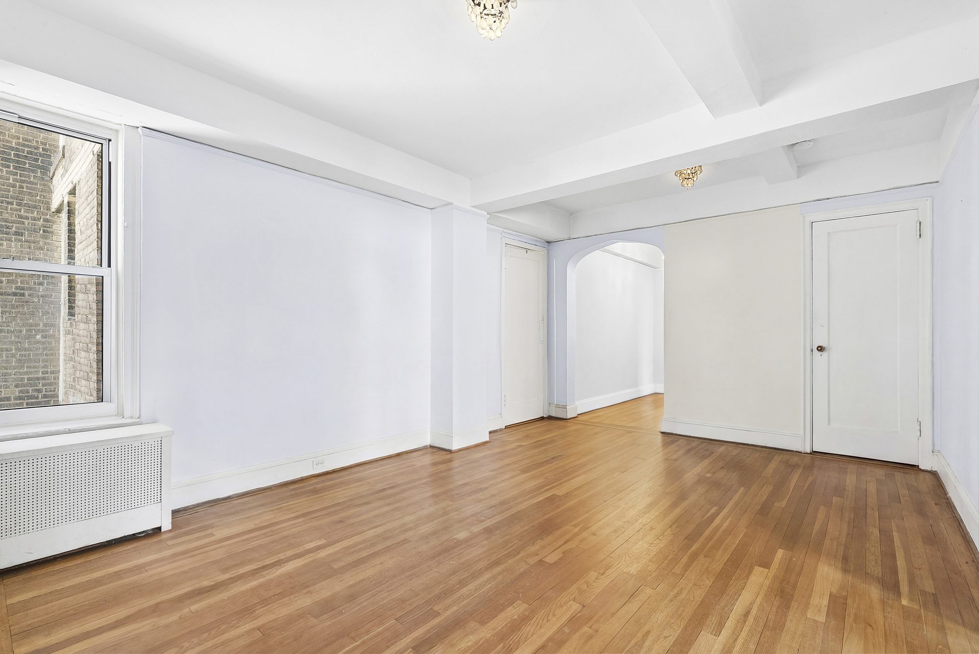 12 West 96th Street, Unit 9A Manhattan, NY 10025 - Photo 4 of 14 a view of an empty room with wooden floor and a window