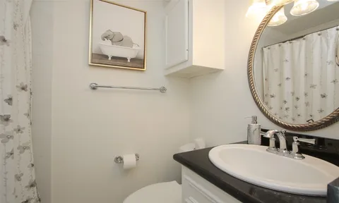 a bathroom with a toilet a sink and a mirror