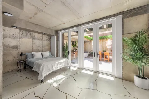 a spacious bedroom with a large bed and a potted plant