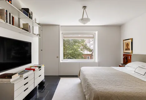 a bedroom with a bed and flat screen tv