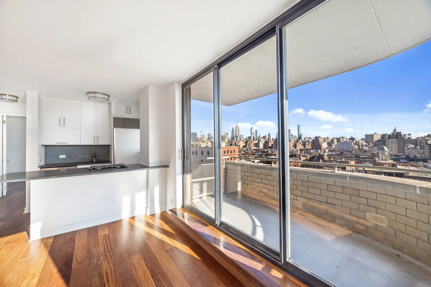 a kitchen with stainless steel appliances wooden floor and a large window