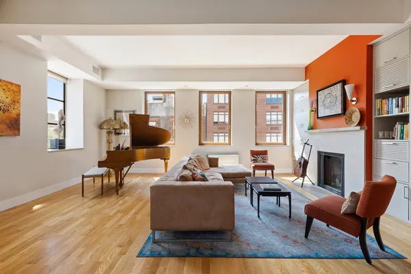 a living room with furniture a fireplace and a large window