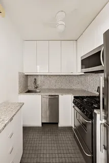 a kitchen with granite countertop a sink stove and microwave