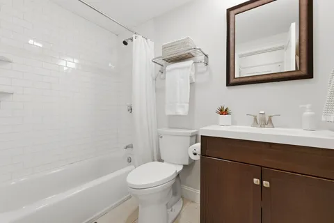 a bathroom with a sink mirror toilet and bathtub