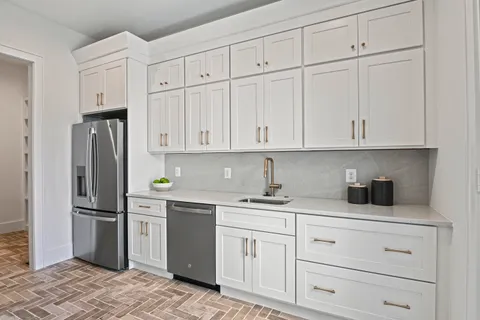 a kitchen with white cabinets and refrigerator