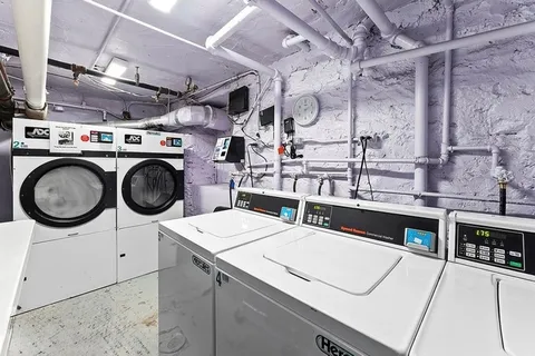 a utility room with dryer washer and a view of living room