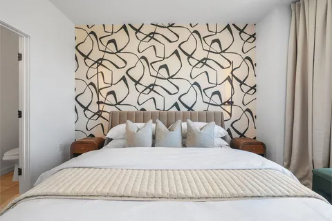 a bedroom with a bed and a lamp on the dresser