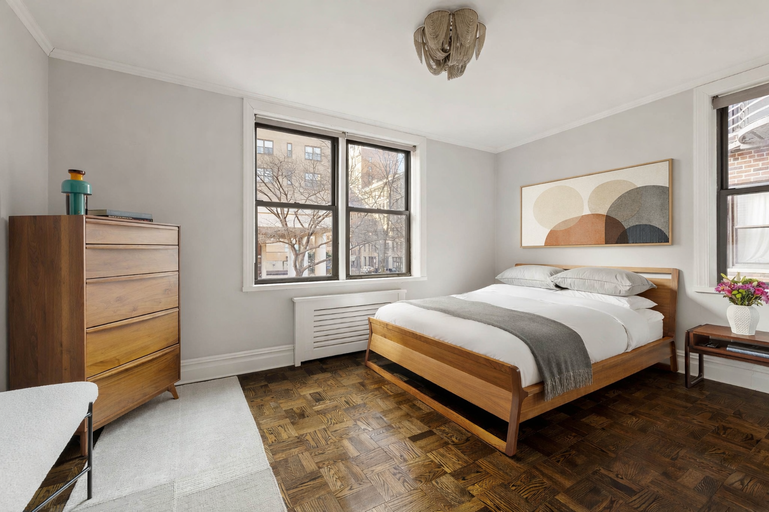 60 East 9th Street, Unit 211 Manhattan, NY 10003 - Photo 5 of 7 a bedroom with a bed and a dresser
