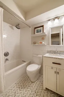 a bathroom with a granite countertop toilet sink and mirror