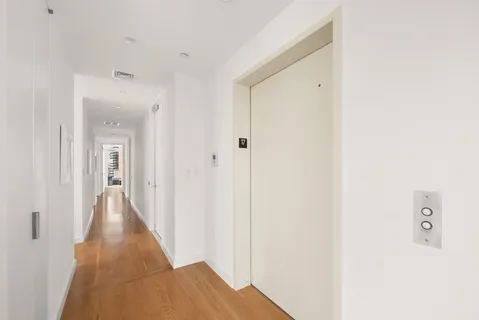 a view of a hallway with wooden floor