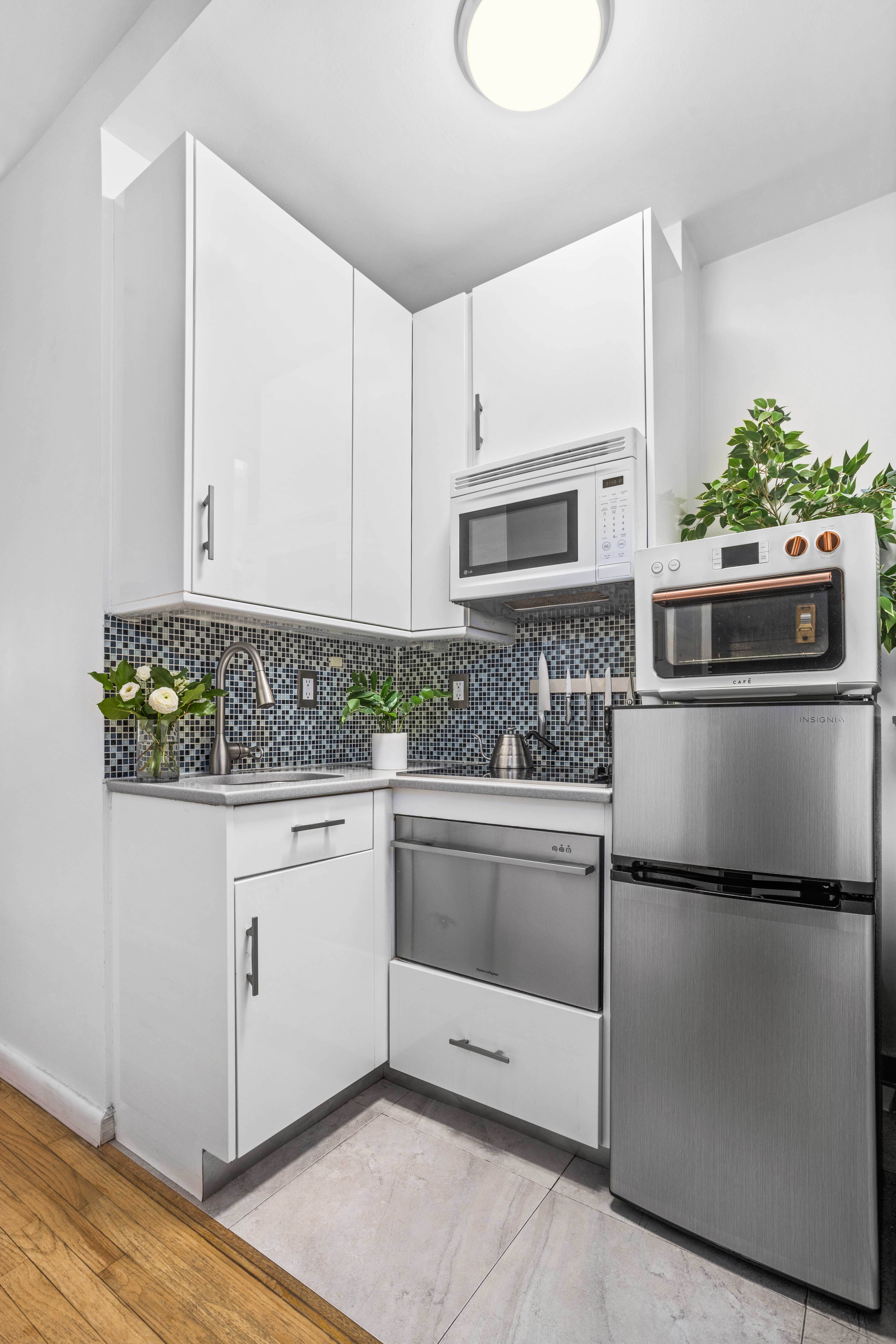 335 West 21st Street, Unit 3RE Manhattan, NY 10011 - Photo 4 of 7 a kitchen with granite countertop white cabinets and stainless steel appliances