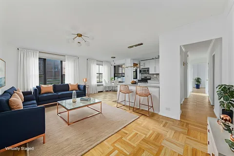 a living room with furniture and a dining table with kitchen view
