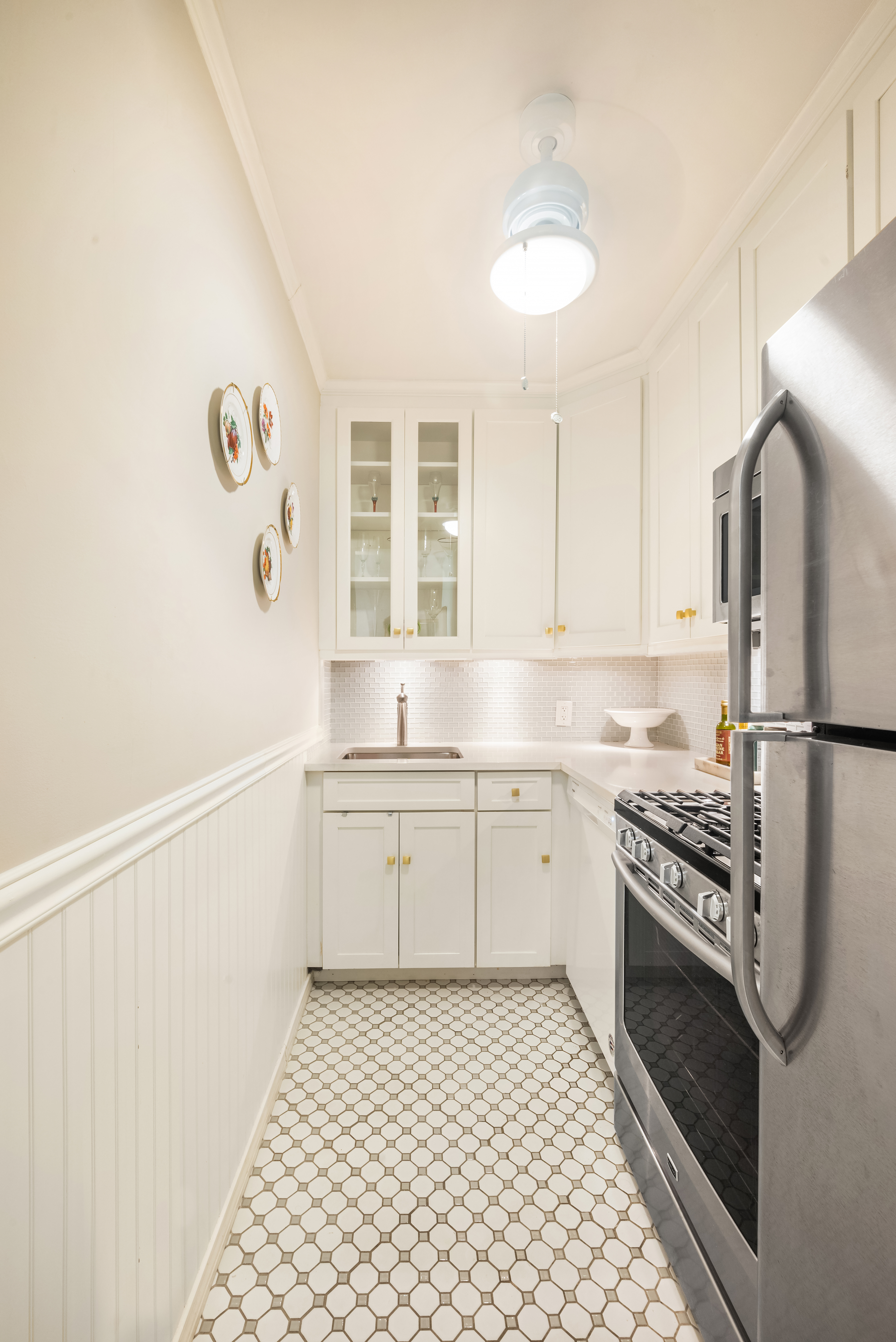 311 East 71st Street, Unit 2B Manhattan, NY 10021 - Photo 4 of 10 a kitchen with a stove a sink and a refrigerator