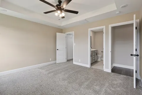 an empty room with closet and a ceiling fan