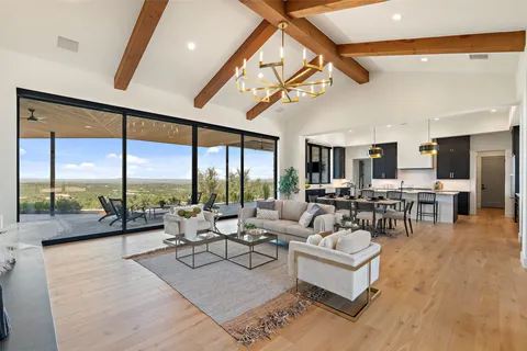 a living room with furniture large window and a table