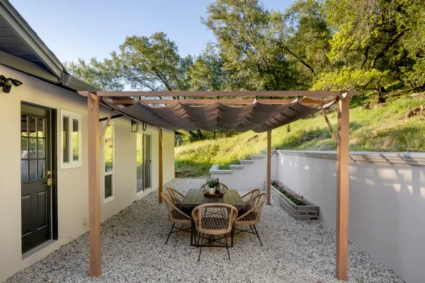 a backyard of a house with table and chairs
