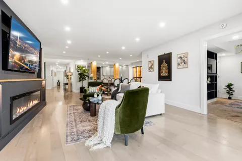 a living room with furniture kitchen view and a fireplace