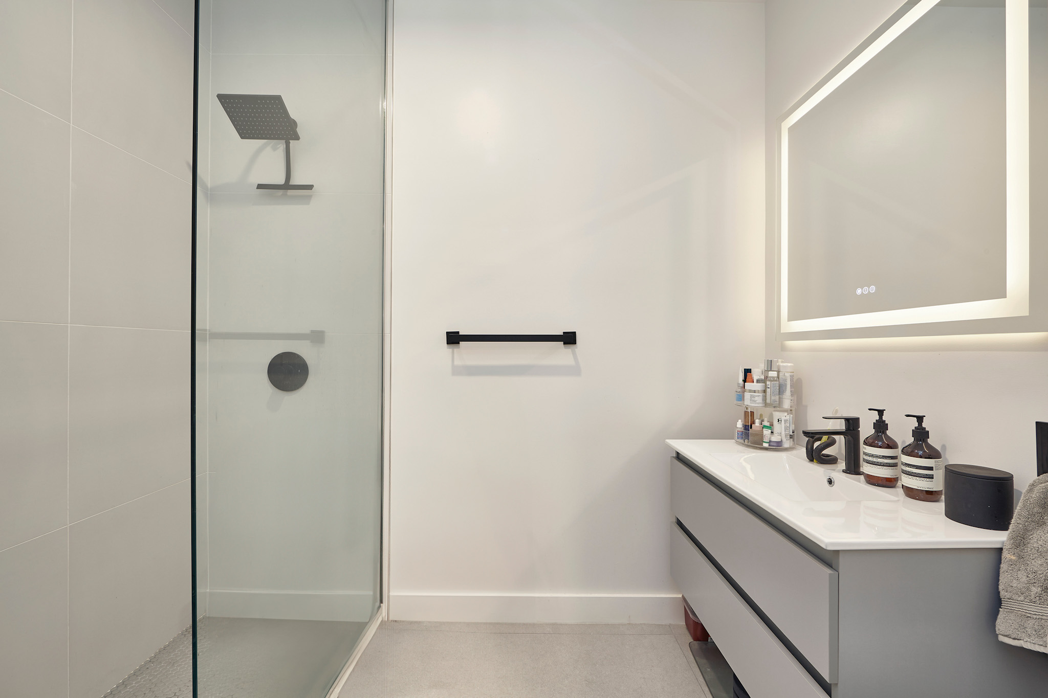 144 North 10th Street, Unit 2D Brooklyn, NY 11249 - Photo 6 of 12 a bathroom with a sink a mirror and shower