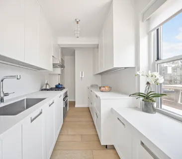 a kitchen with a sink a stove and cabinets