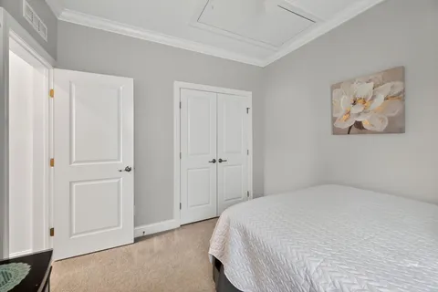a bedroom with a bed and painting on the wall
