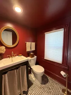 a bathroom with a toilet a sink and a mirror