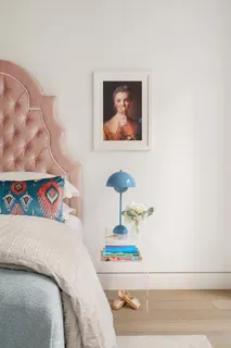 a bedroom with a bed and a painting on the wall