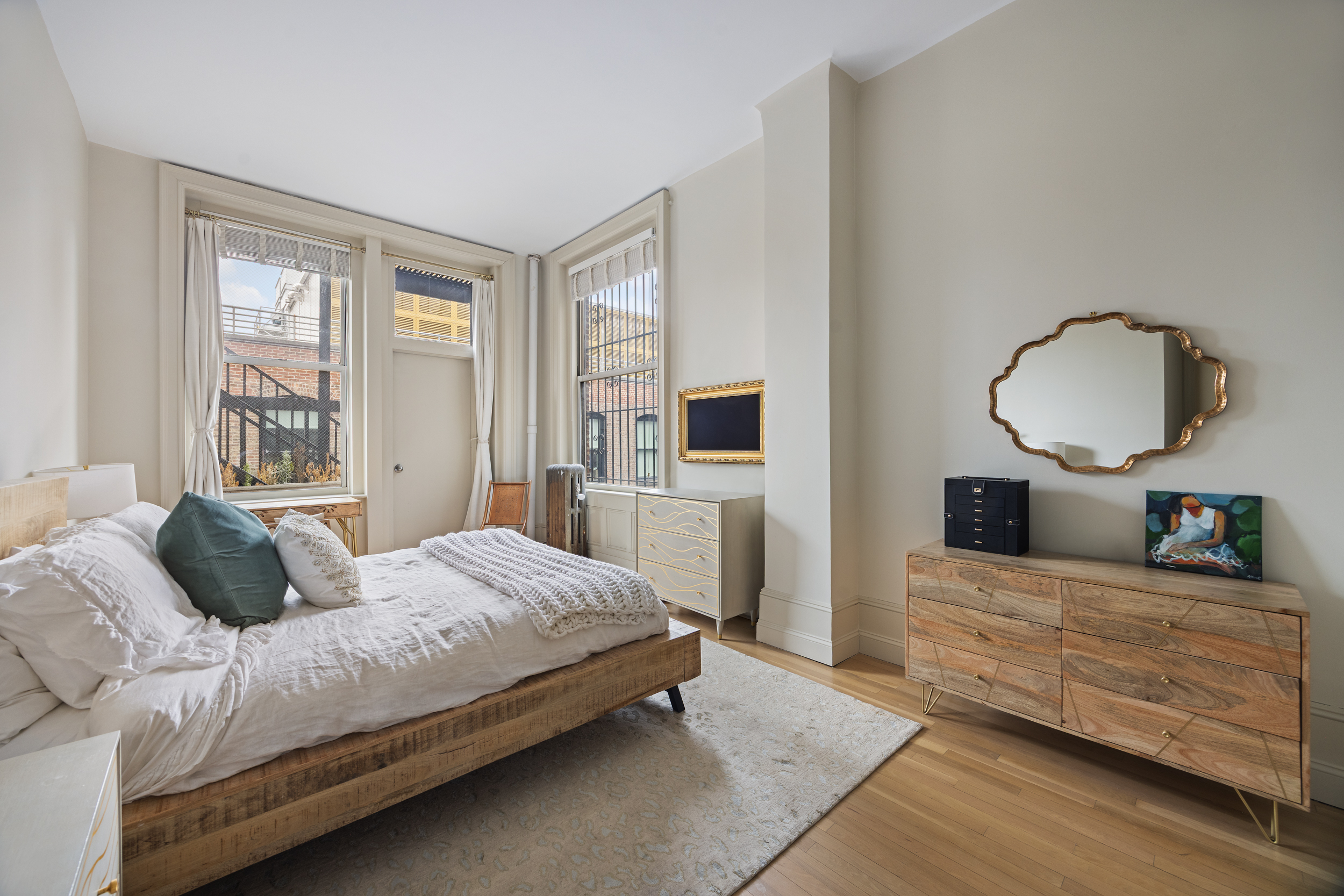 714 Broadway, Unit 8 Manhattan, NY 10003 - Photo 22 of 23 a bedroom with a large bed and a dresser