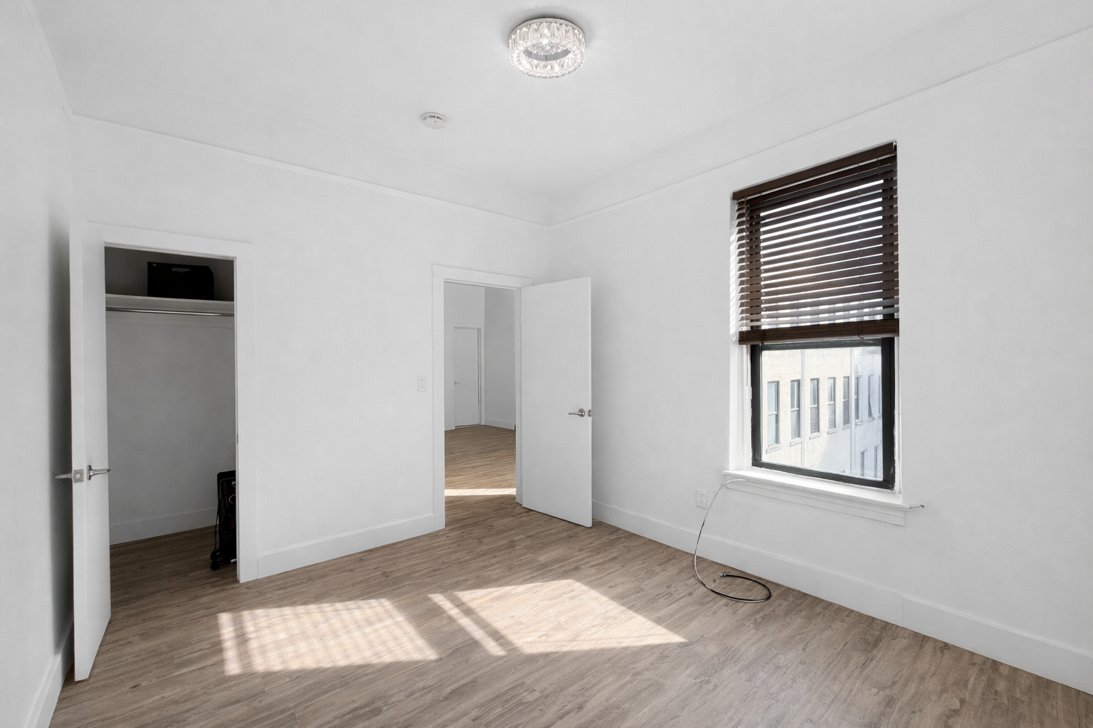 164 West 128th Street, Unit 3C Manhattan, NY 10027 - Photo 5 of 8 a view of an empty room with wooden floor and a window